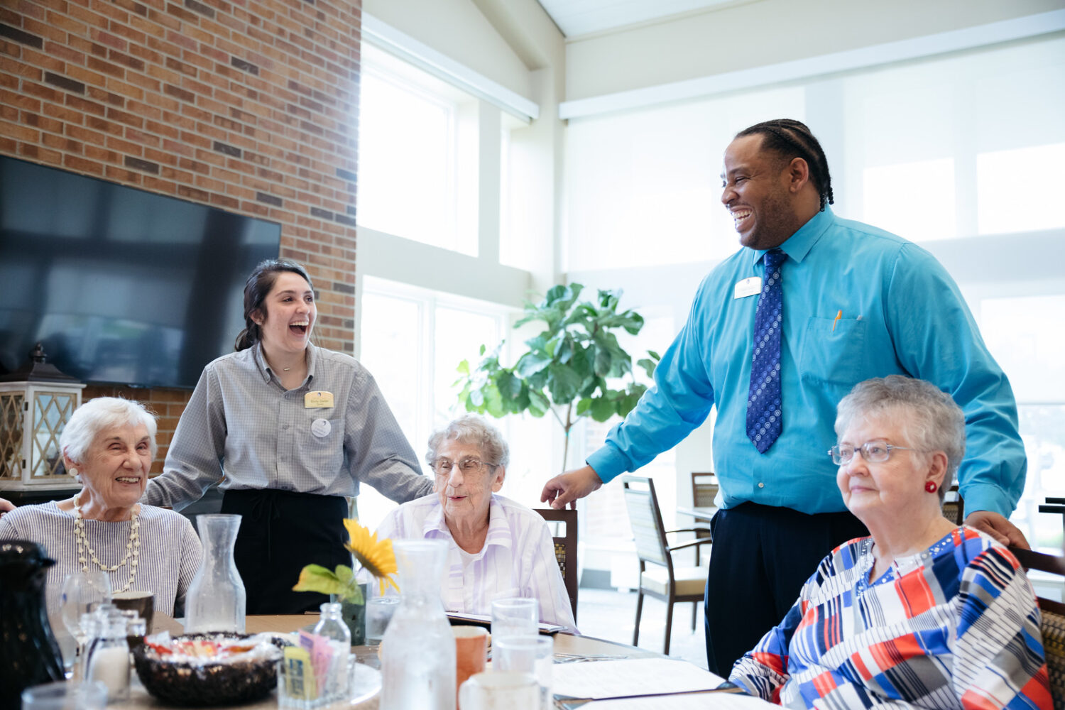 Morrison Living servers smiling with residents in community at the table