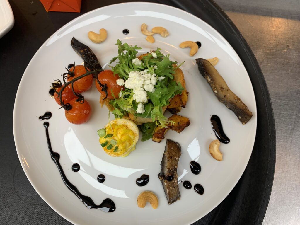 salad served with a variety of vegetables including arugula, blood orange balsamic dressing, acorn squash, Portobello mushrooms, and goat cheese