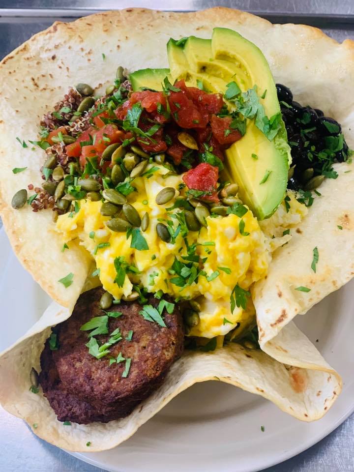 tortilla shell balanced bowl with vegetables, avocadoes, eggs, tomatoes, and leafy greens