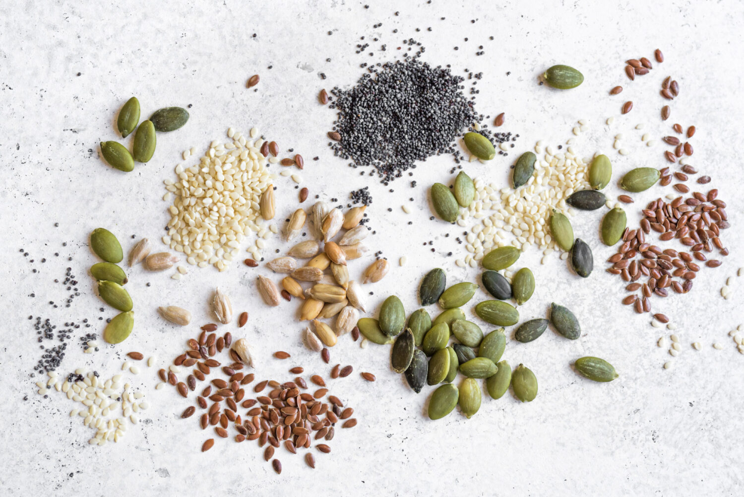 Various Seeds on white background. Assortment of seeds, healthy food ingredients, superfood, top view, copy space.