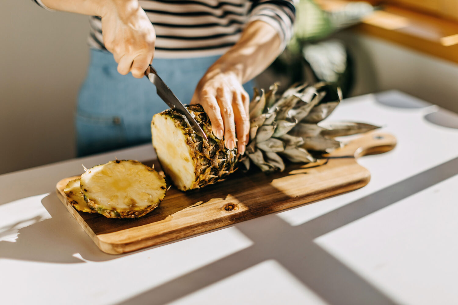 Woman cutting pineapple on desk