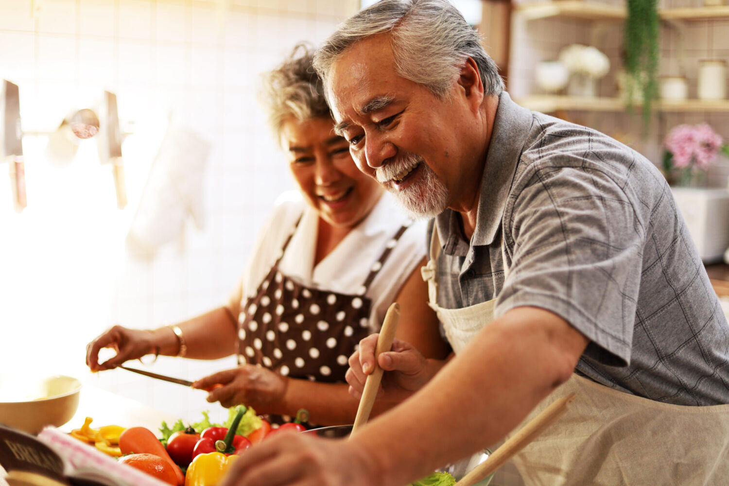 Happiness senior elderly couple having fun in kitchen with healthy food for working from home. COVID-19