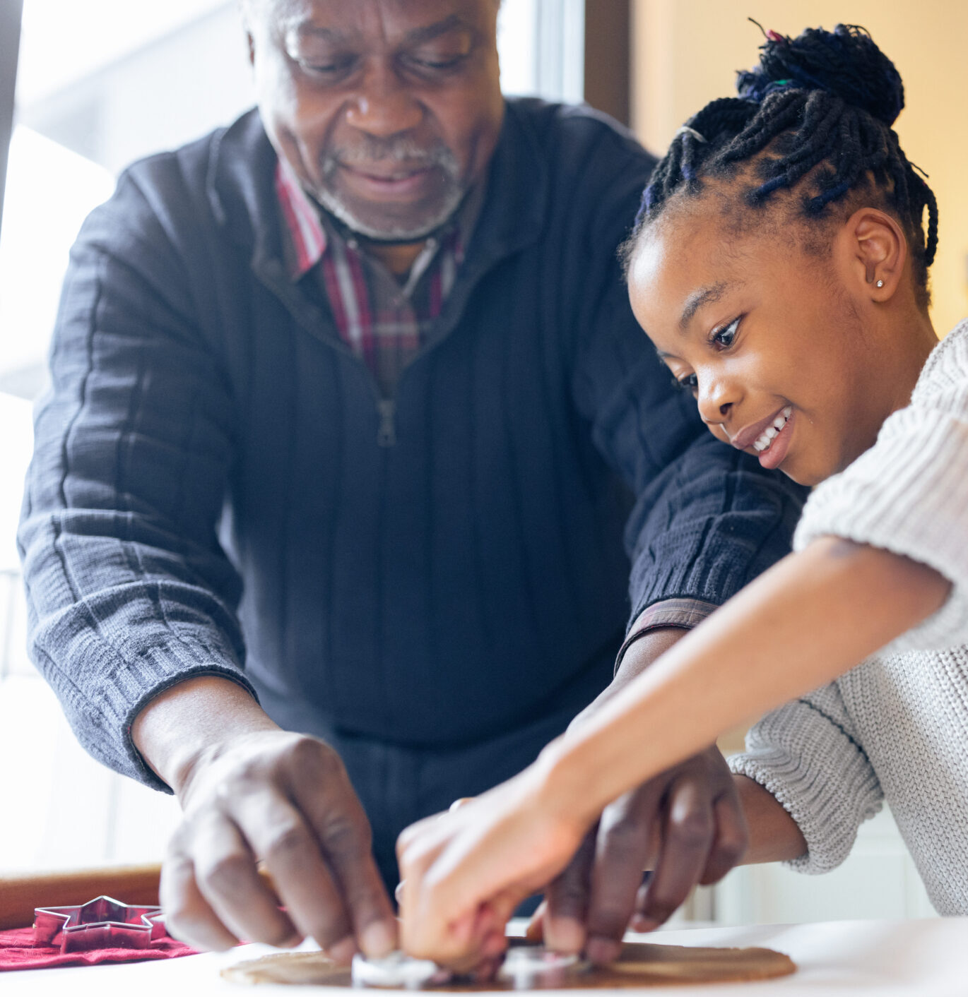 Little girl making Christmas gingerbread cookies with a grandparents