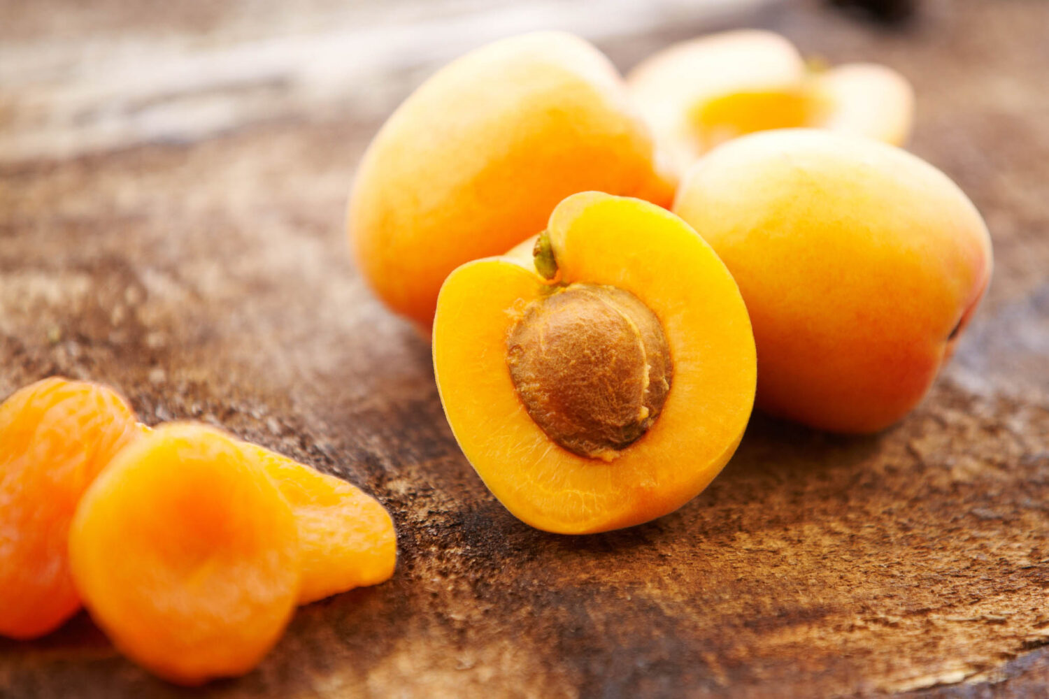 Organic fresh and dried apricots on distressed wooden surface, close-up